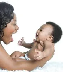 A woman holding a baby and laughing.