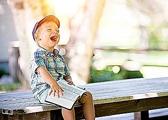 A little boy sitting on top of a bench.